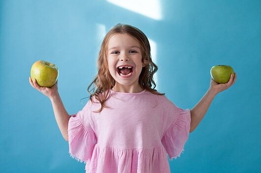 Kind mit Äpfeln in der Hand